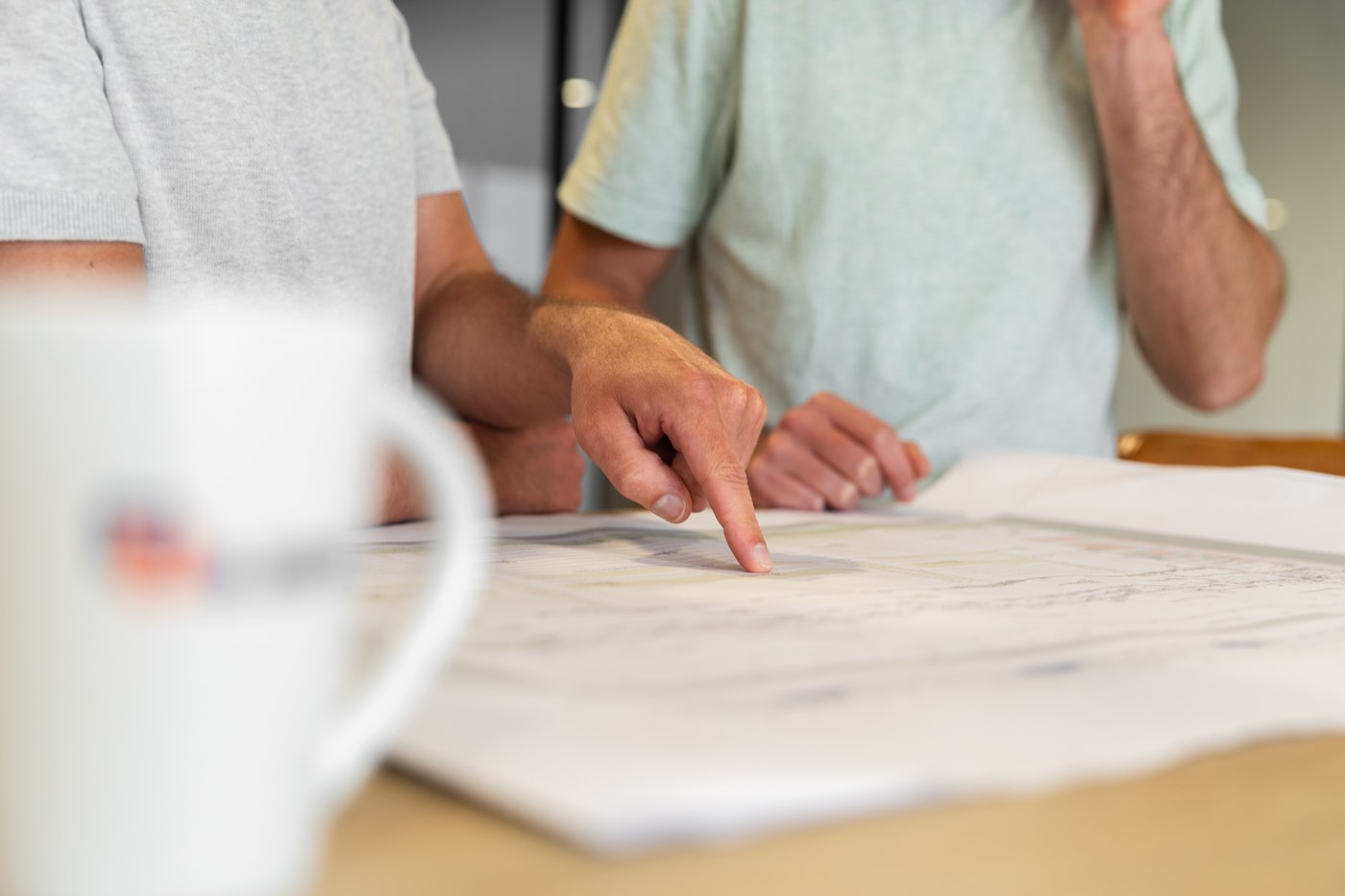 Two people going through a layout drawing together at a table