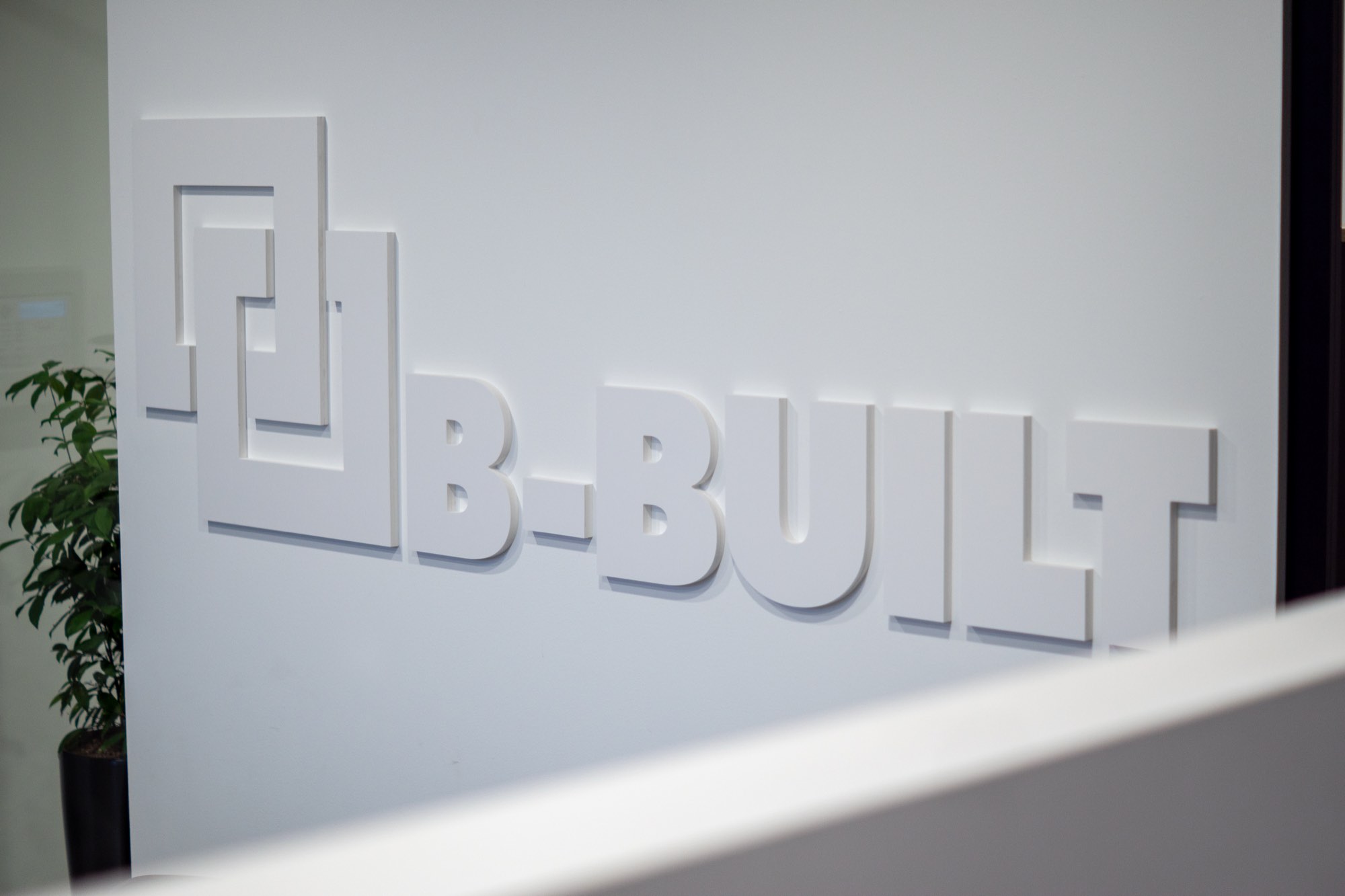 The B-Built logo in relief on the office reception wall