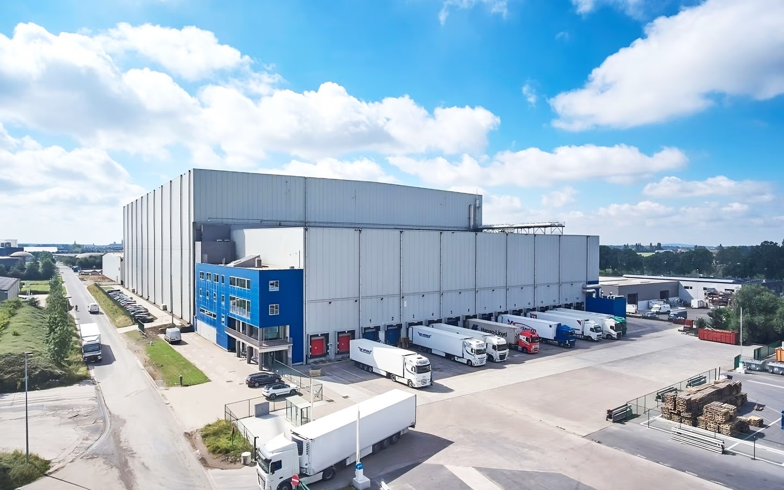 Long cold store with a blue office block at the front and trailers along the loading docks
